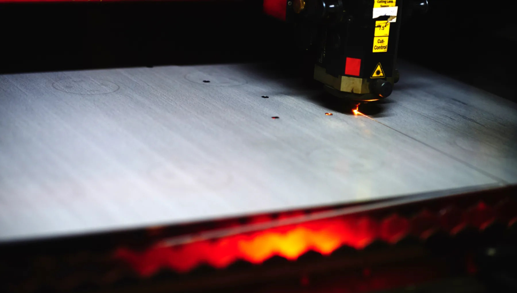 Laserskärningsmaskin i drift som skär metallplåt med präcisionslaser i Lalmeks produktionsanläggning