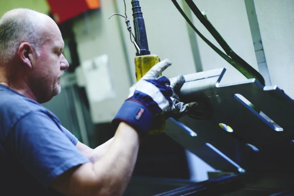 Svetsare bearbetar hydraulcylinder med precisionssvetsning i Lalmeks produktionsanläggning i Ölmstad