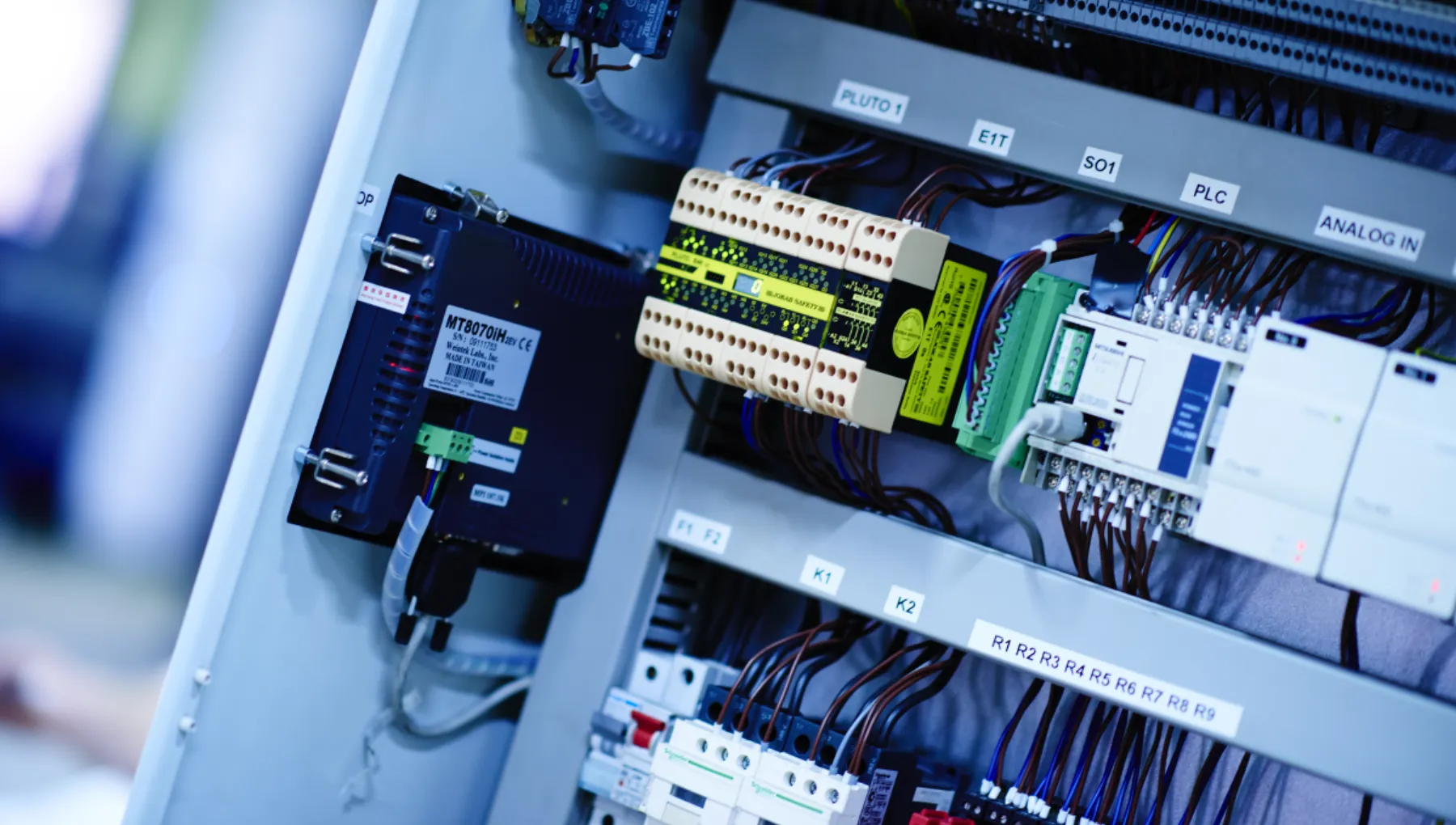 Industriell styrelektronik med PLC-system, reläer och kabeldragning i kontrollenhet för hydraulsystem