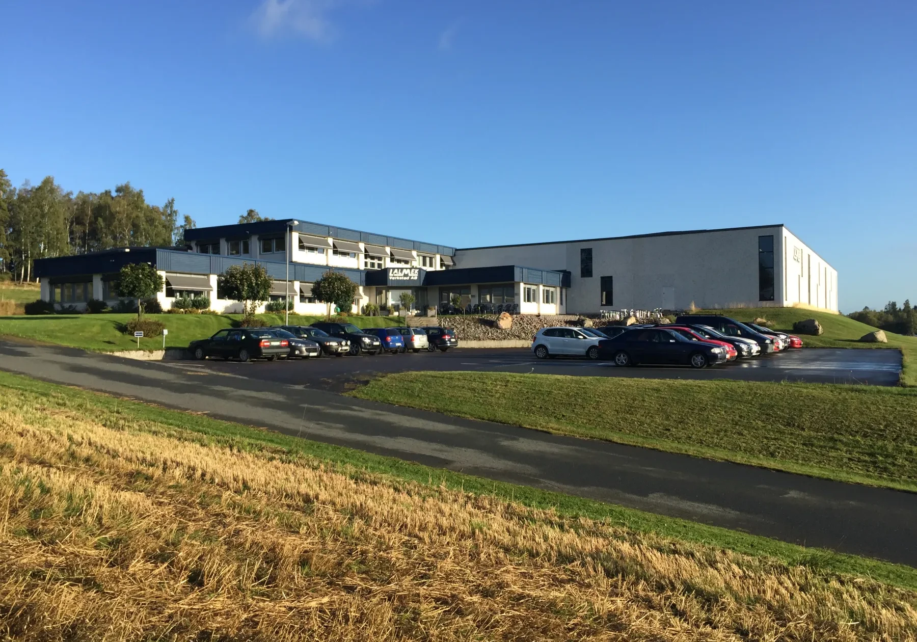 Lalmek Hydraulics produktionsanläggning i Ölmstad med modern industribyggnad och personalens bilar på parkeringen