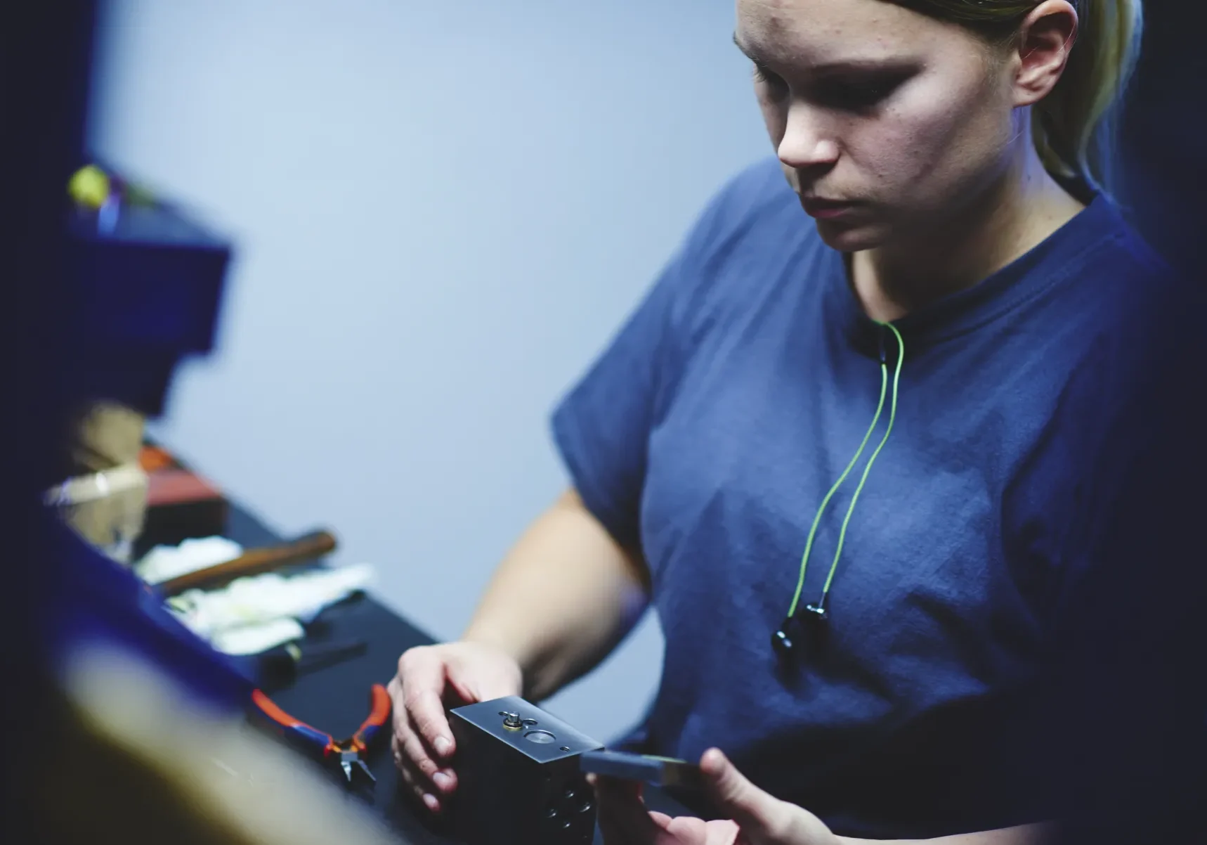 Tekniker använder mobiltelefon med hörlurar i industriell miljö för kommunikation och systemövervakning